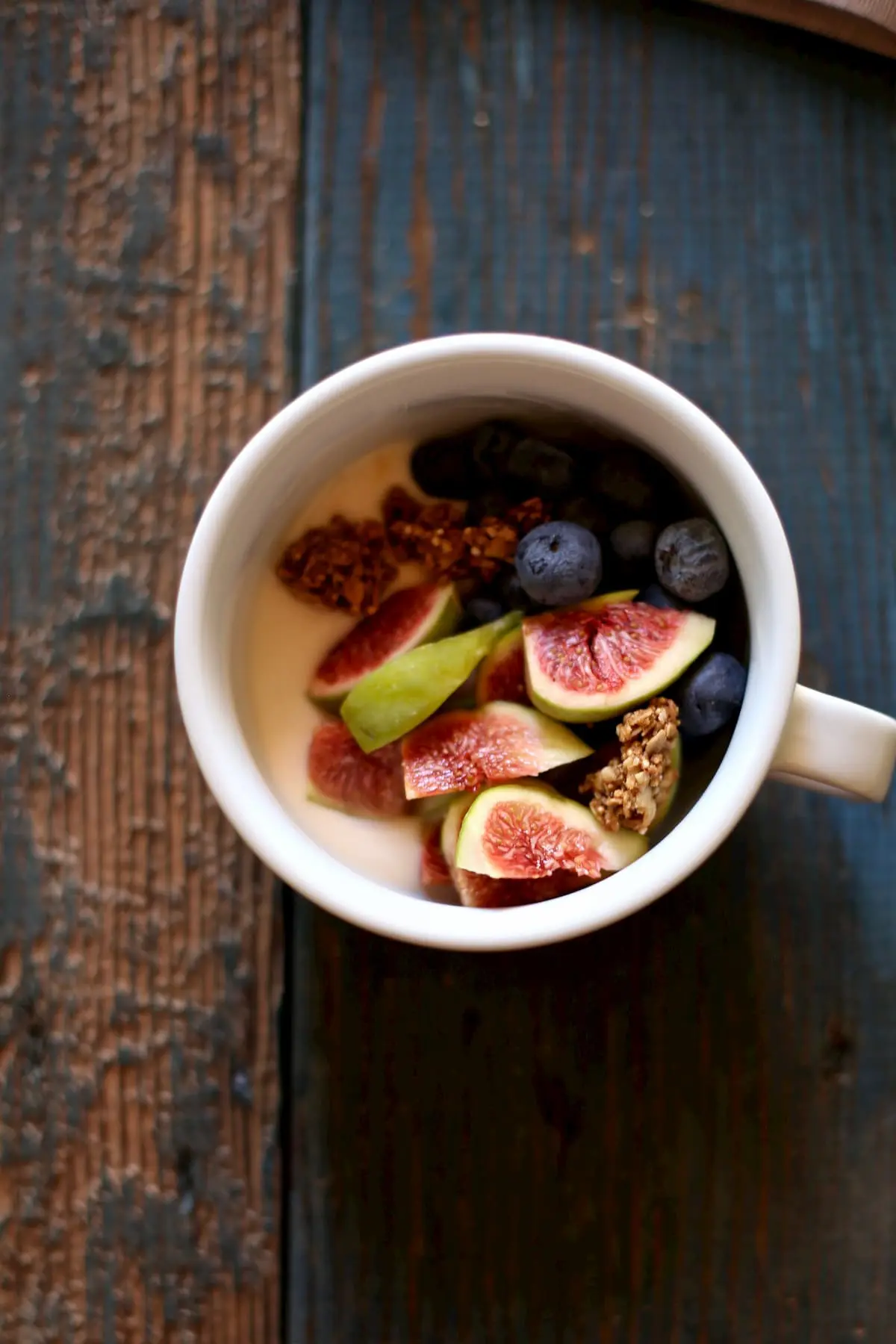 One bowl of yogurt and fresh figs on a wooden table