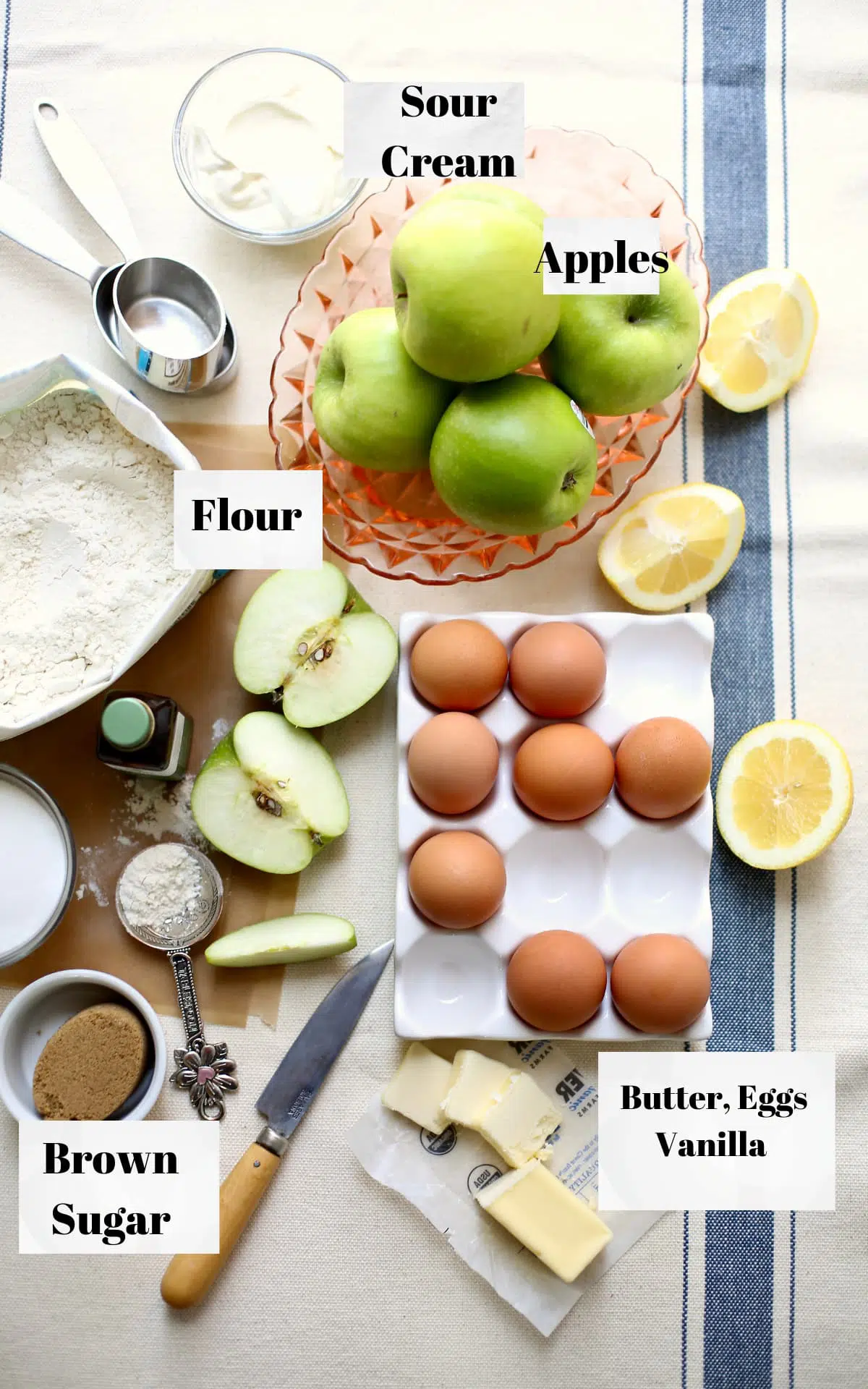 a photo of a table of ingredients for cake: apples, flour, eggs, butter, with a text overlay saying the names of the ingredients.