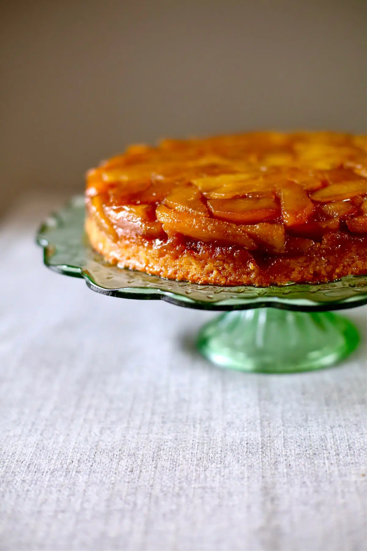 an apple cake on a green glass cake stand.