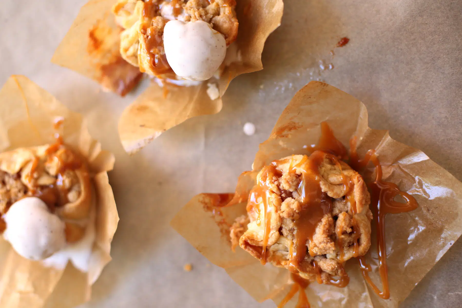 three small apple pies on a table