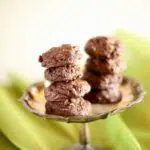 a small silver tray of cookies on a table with green tablecloth under it