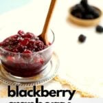 a bowl of cranberry sauce on a table with a few blackberries behind it.