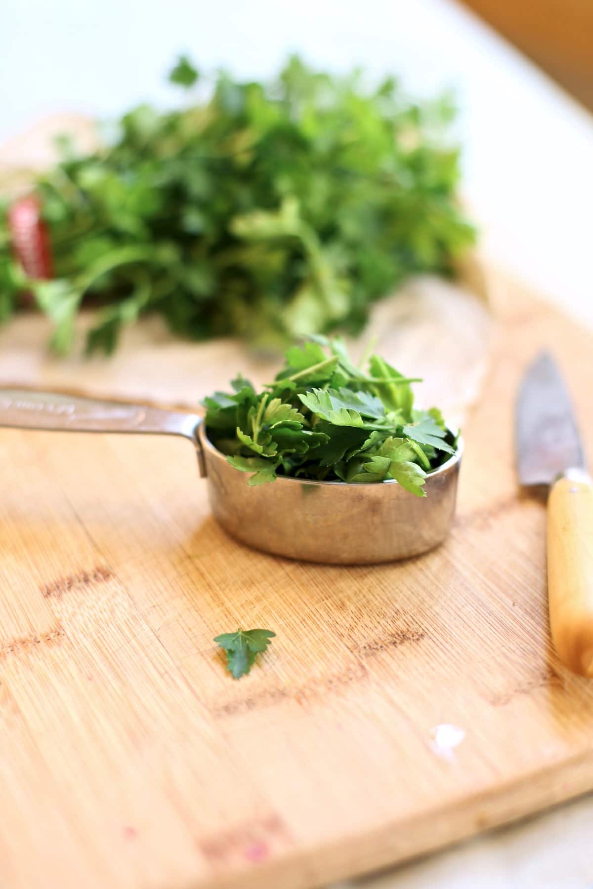 parsley in a silver measuring cup