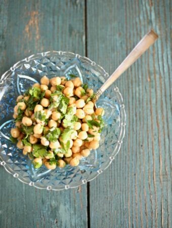 chickpea salad in a blue bowl on a blue table