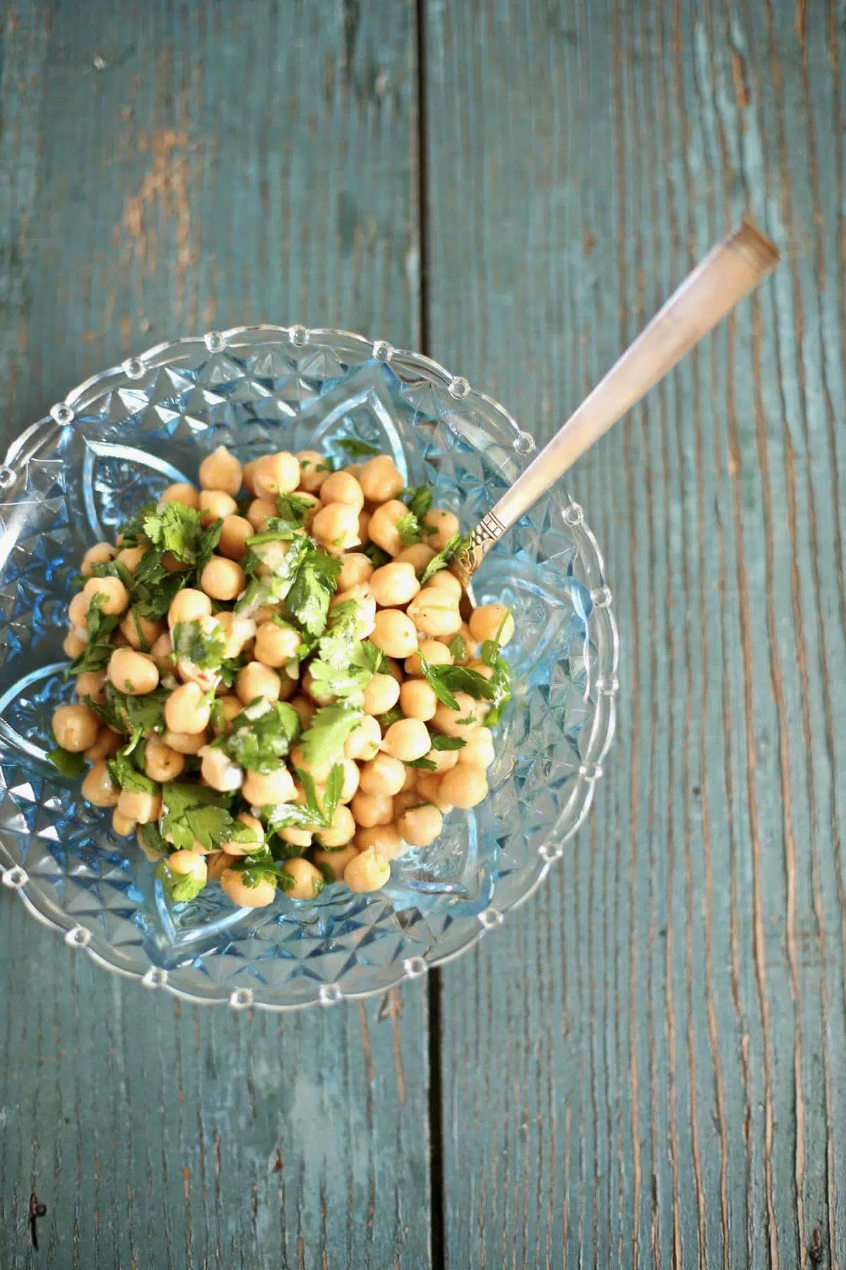 chickpea salad in a blue bowl on a blue table