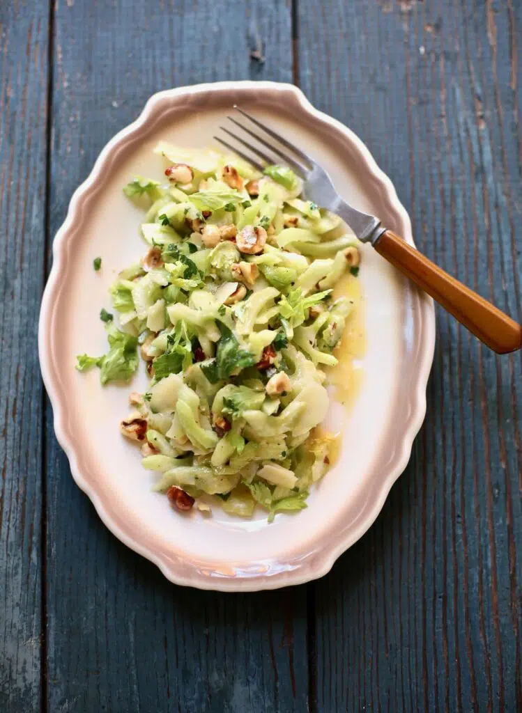 celery salad on a whote plate with brown trim