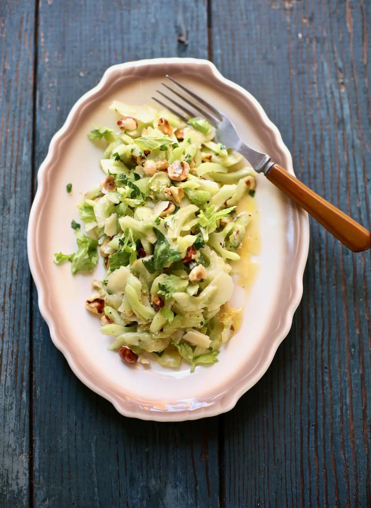 celery salad on a whote plate with brown trim 