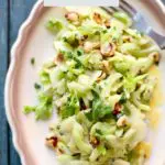 celery salad on a white plate with brown trim