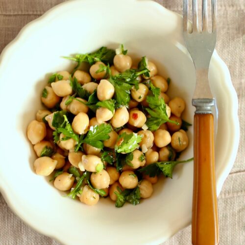 an overhead photo of a white bowl of chickpea salad.