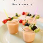 pineapple smoothies with fruit kabobs on a green platter