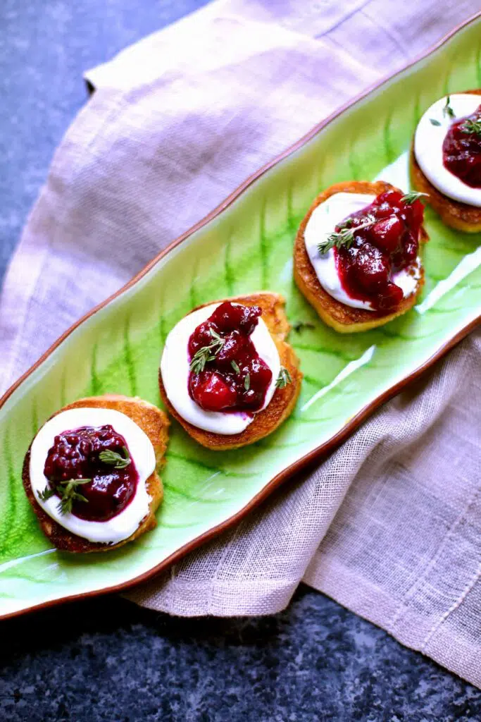 a green serving tray with cheesy toasts on it.