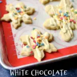 white chocolate snowflake cookies with white text on a baking sheet