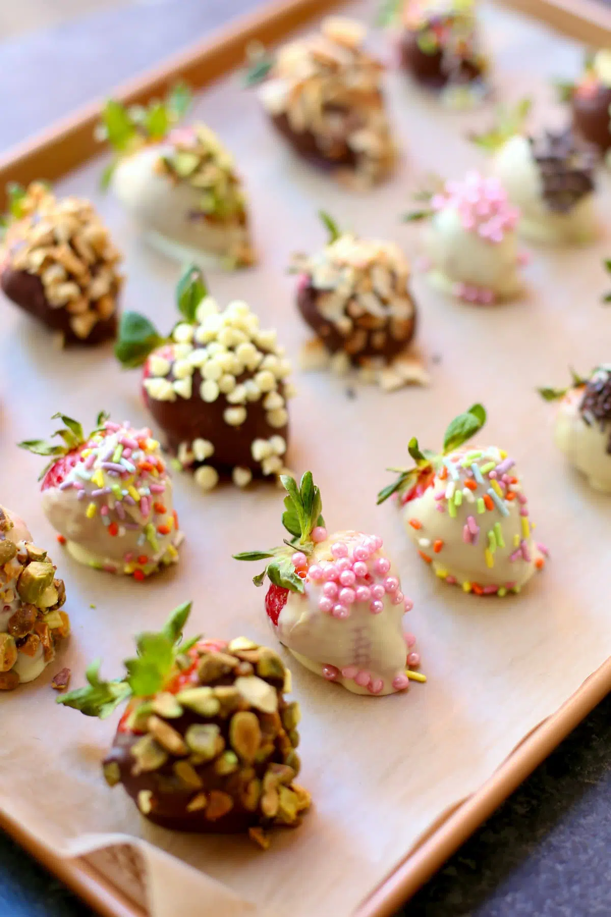 a tray of chocolate and sprinkle dipped strawberries