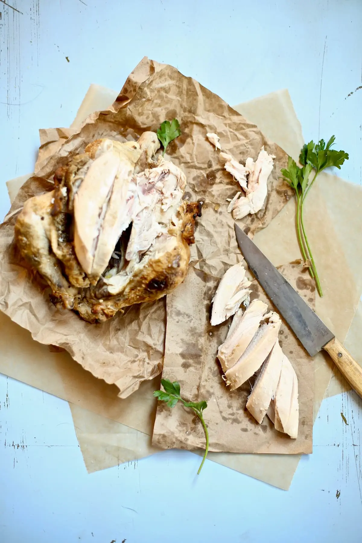 a whole chicken being cut up and portioned with a knife.
