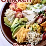 a bowl of chicken, cheese, avocado, rice, tomatoe and lettuce in a round wooden bowl with text overlay.