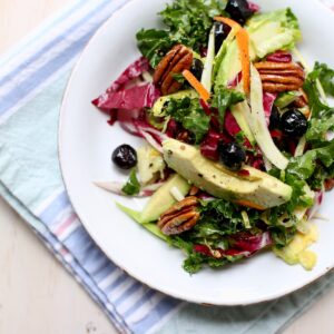 a white plate of salad, square image.