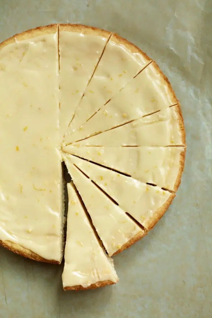 a round of lemon iced shortbread, cut in slices on a piece of parchment paper