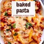 a full frame photo of baked pasta with chicken sausage in a white casserole dish with a small white square and text saying the recipe name.