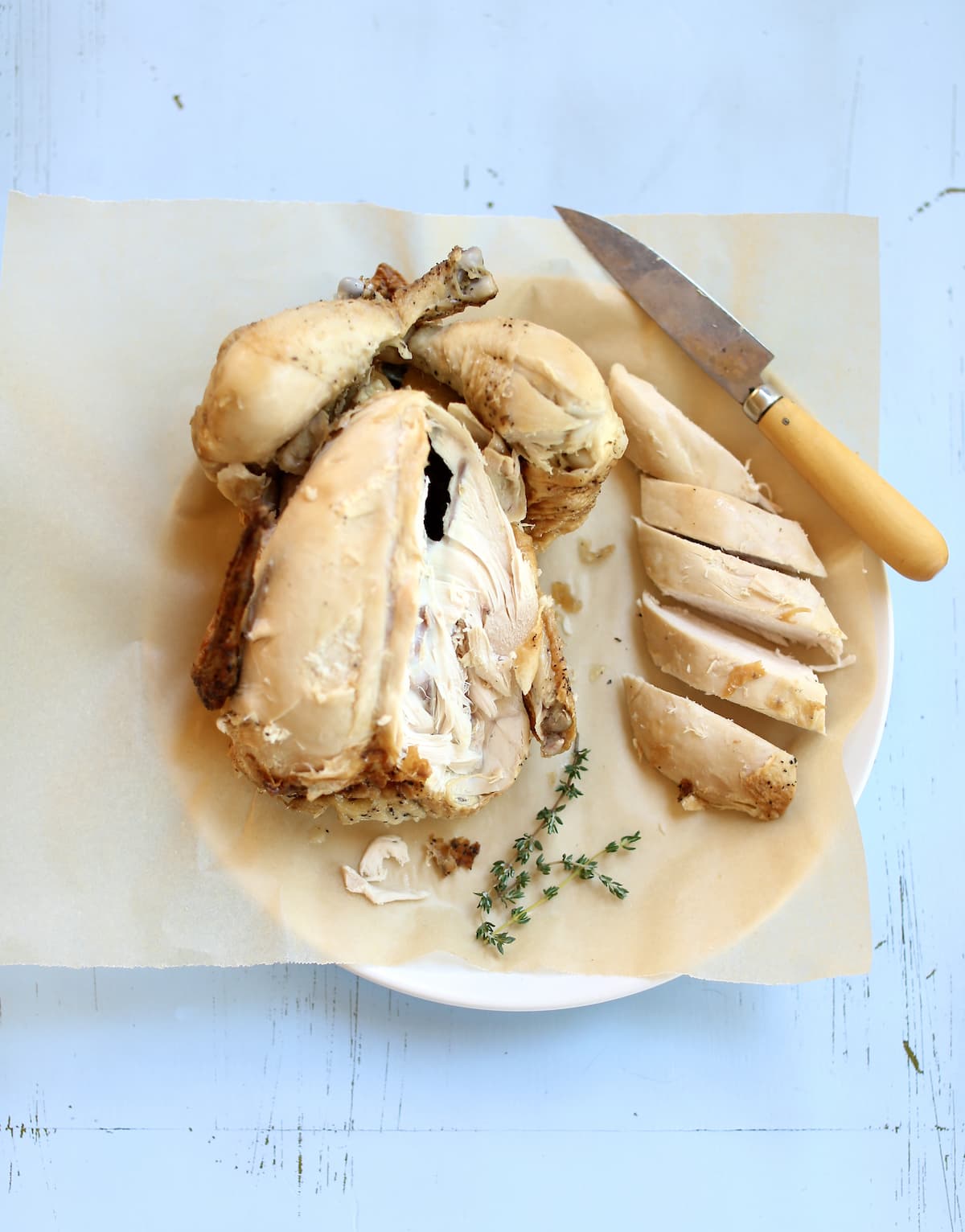 a whole chicken with a knife, showing how to cut it on a blue background board.