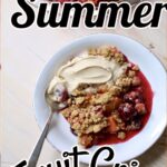 a white dish of summer fruit crisp with vanilla ice cream and a spoon.