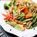 a white platter of noodles and vegetables.