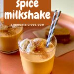 a pumpkin milkshake with a gray straw on a copper platter and two cookies in the background. A box with text saying this recipe name.