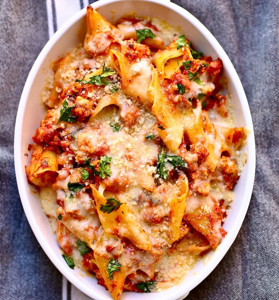 baked pasta in a white casserole dish on a gray tablecloth