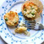 two cauliflower appetizers on a blue and white plate with a fork