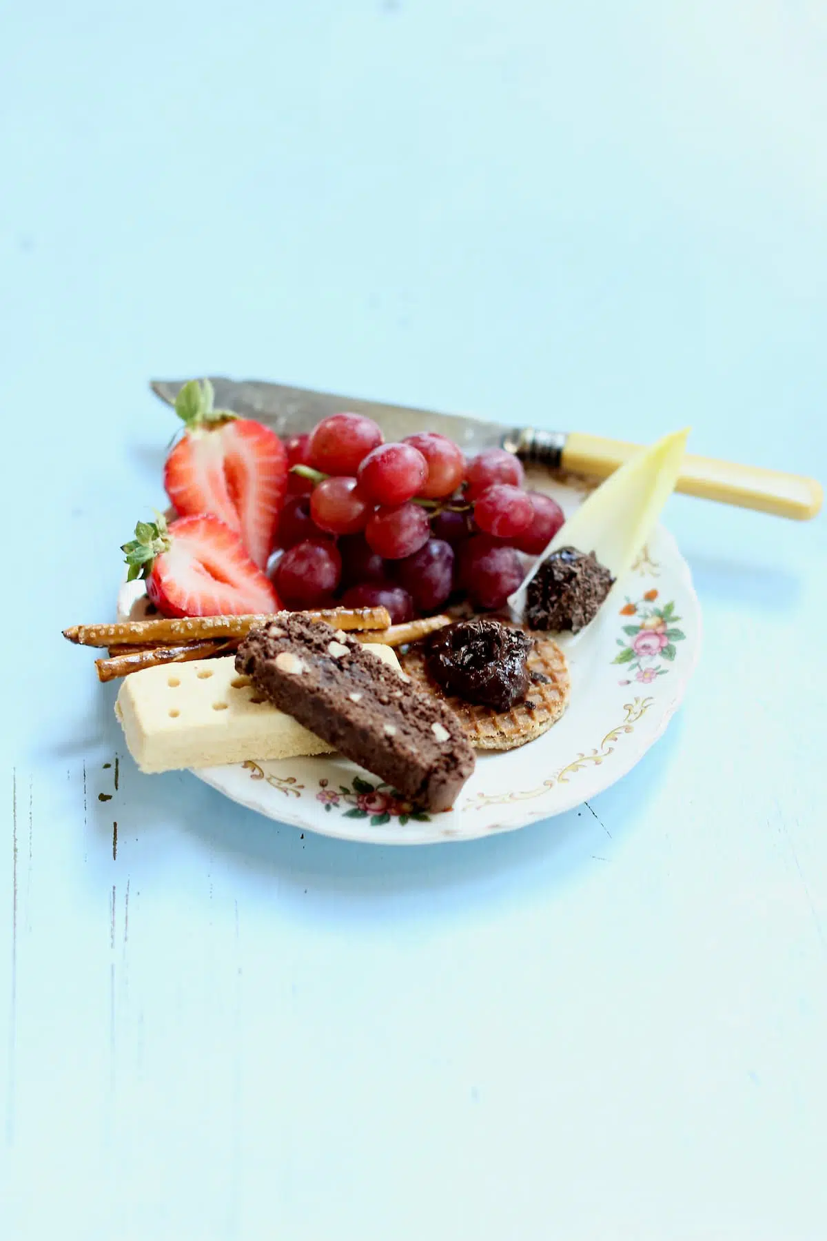 a small dessert plate with vegetables and cookies and fruits.