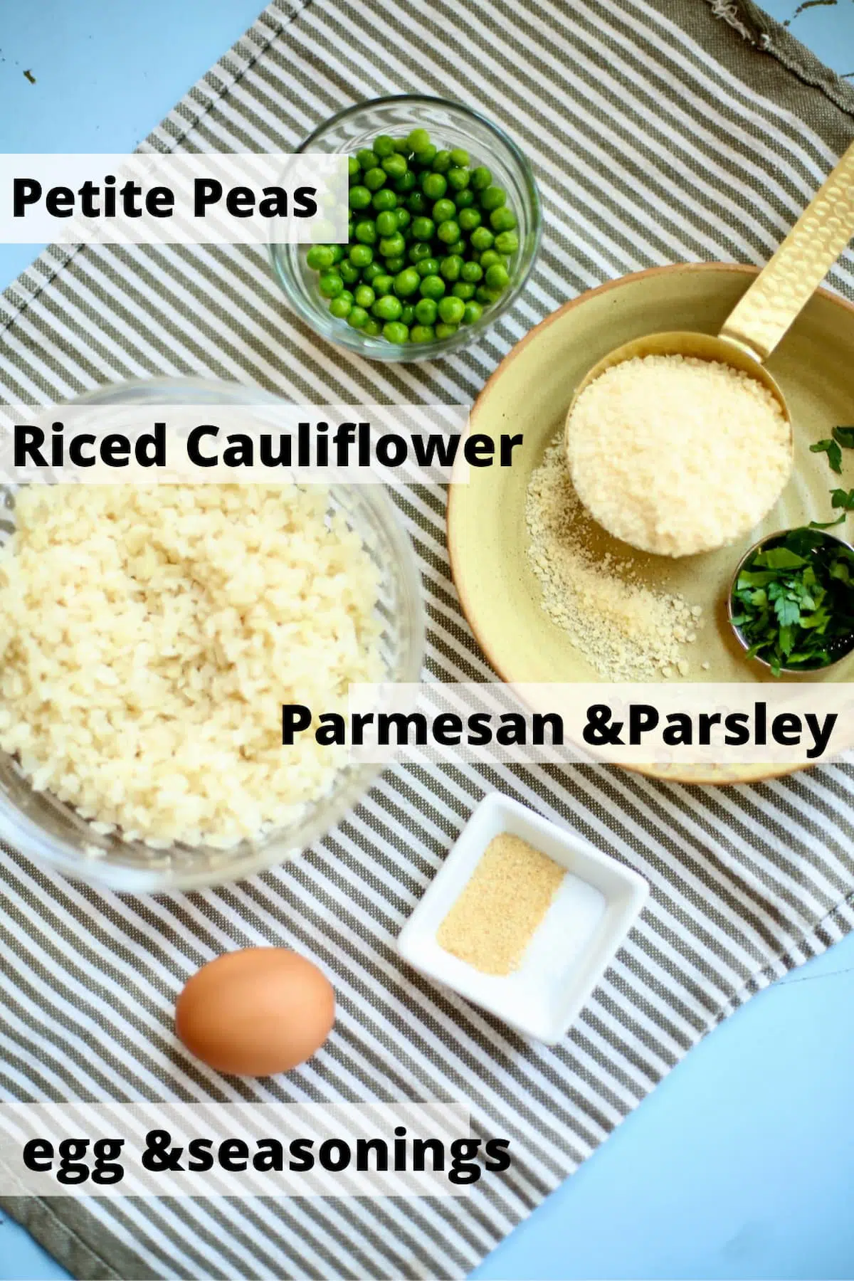 a table with ingredients, cauliflower, parmesan cheese and an egg and seasonings,