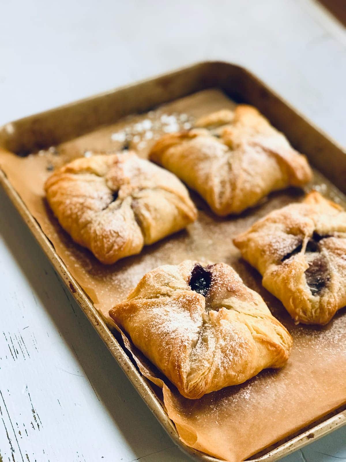 four pastries with powdered sugar