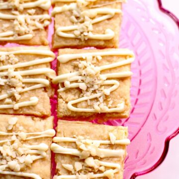 a close up photo of shortbread with white chocolate and macadamia nut on top.