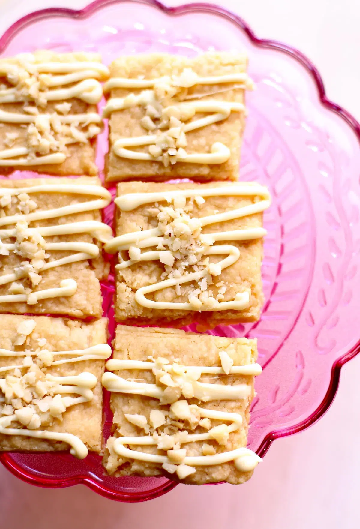 a close up photo of shortbread with white chocolate and macadamia nut on top.