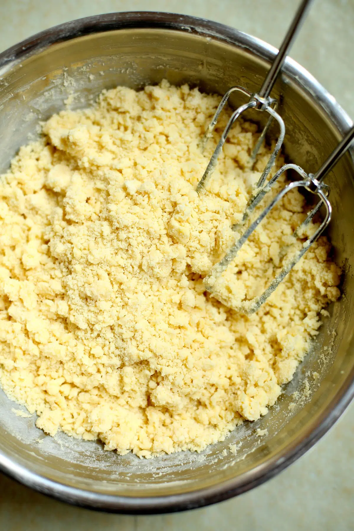 a bowl of flour and butter that's been combined together.