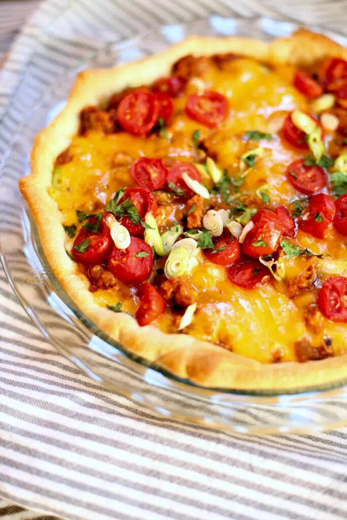 a cooked taco pie on a striped tablecloth.