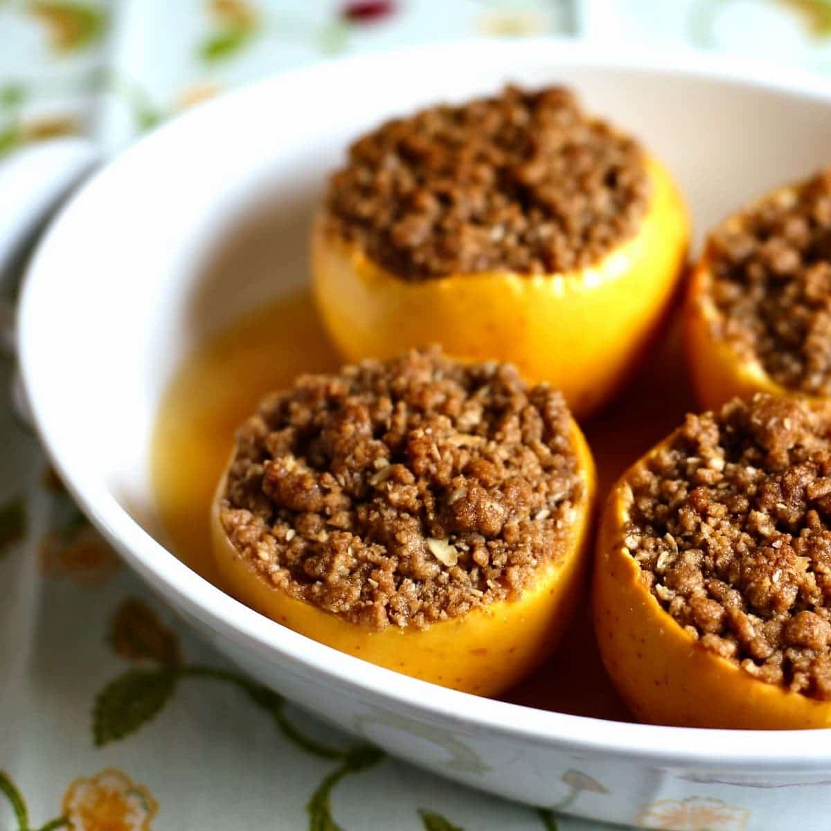 a baking dish of baked apples with crumble topping.