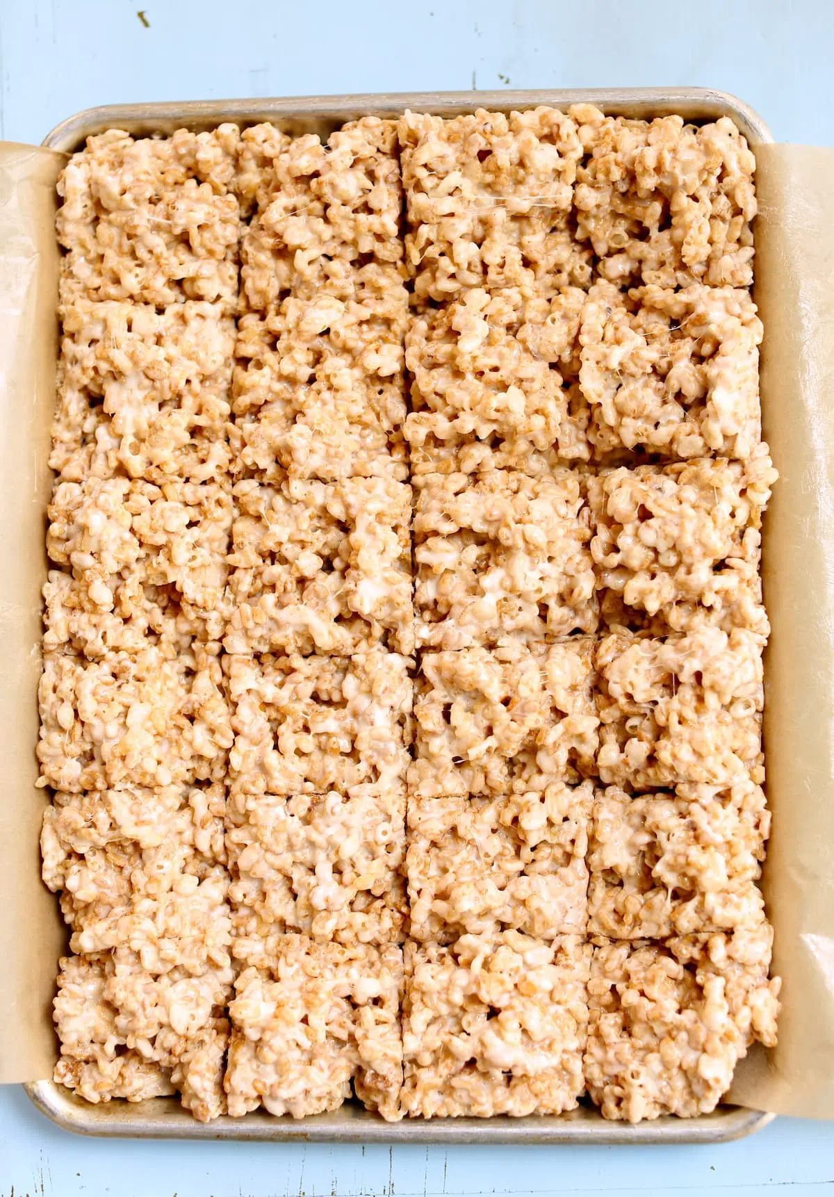 a tray of cereal krispy treats on a tray, cut into squares.