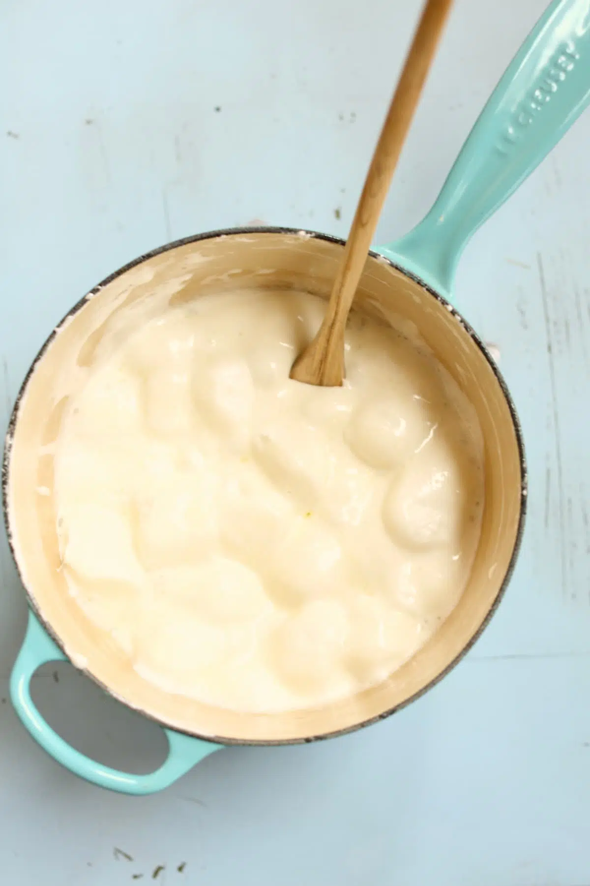 a saucepan with melted marshmallows in it, and a wooden spoon.