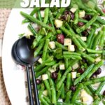 a green bean salad on a serving platter with utinsils, and text overlay saying the recipe and blog name.