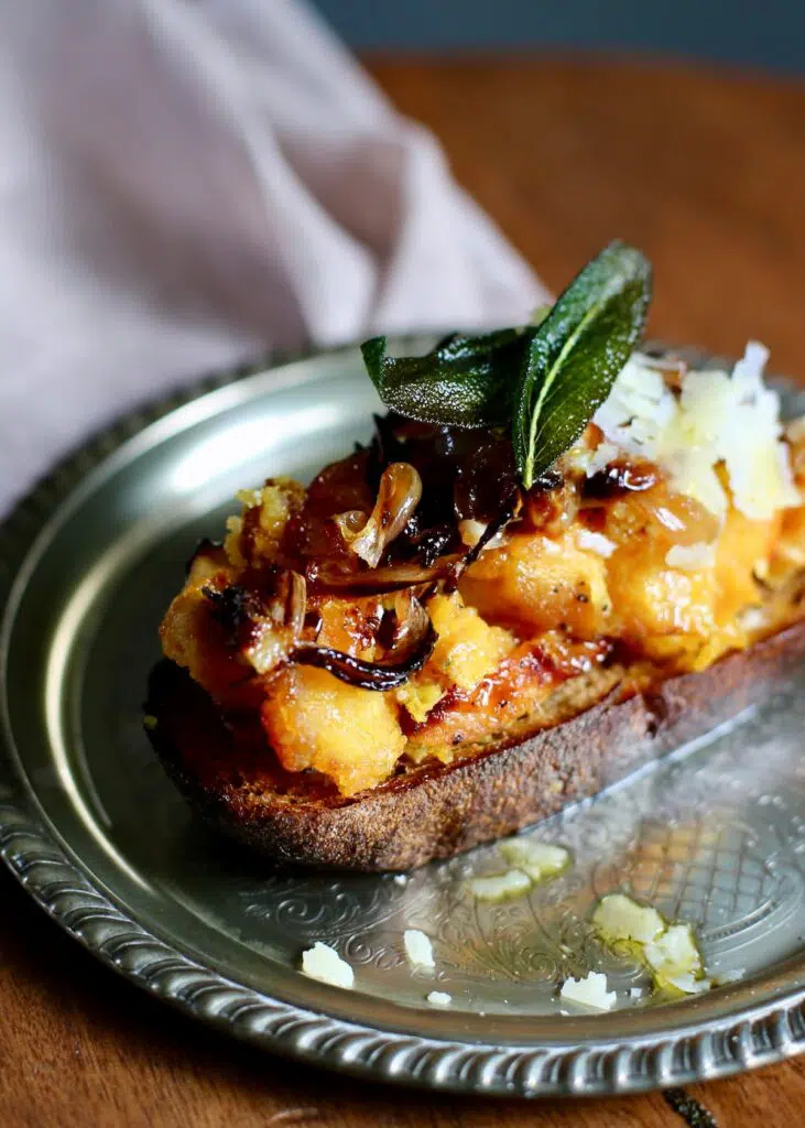 squash toast on a silver plate.