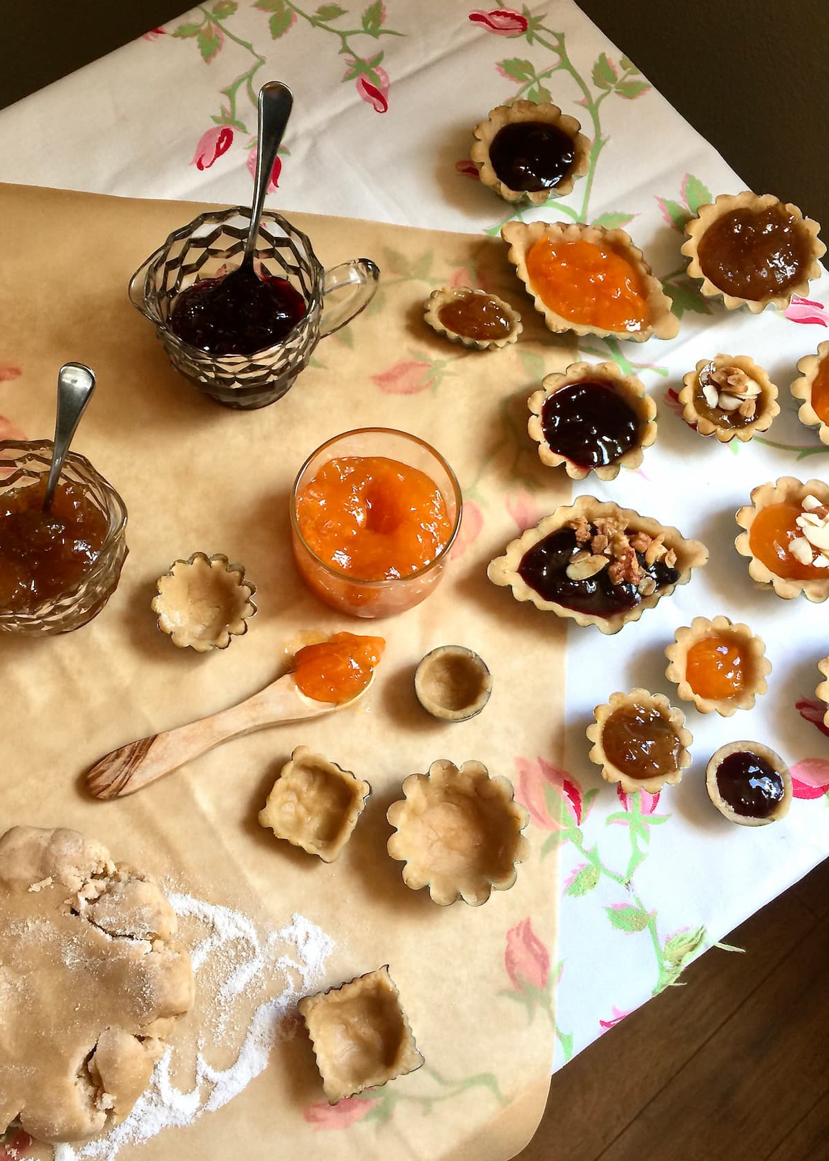 various shapes and sizes of mini jam pies on a table.
