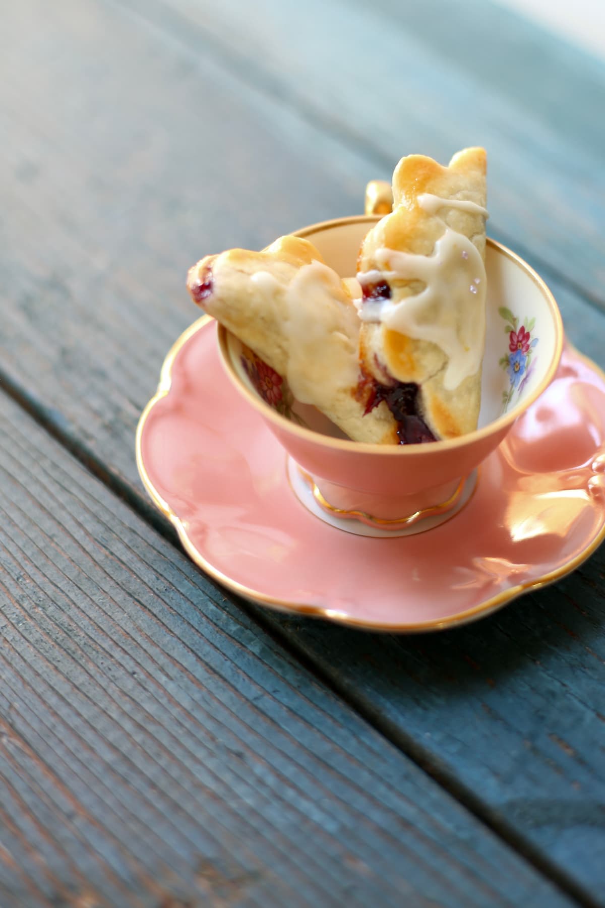 a pink teacup with two mini pies inside.