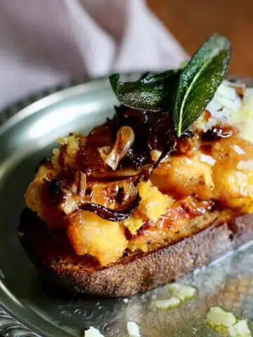 a silver plate with squash crostini
