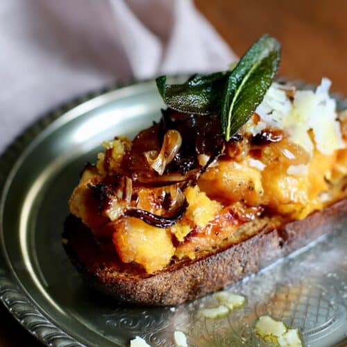 a silver plate with squash crostini