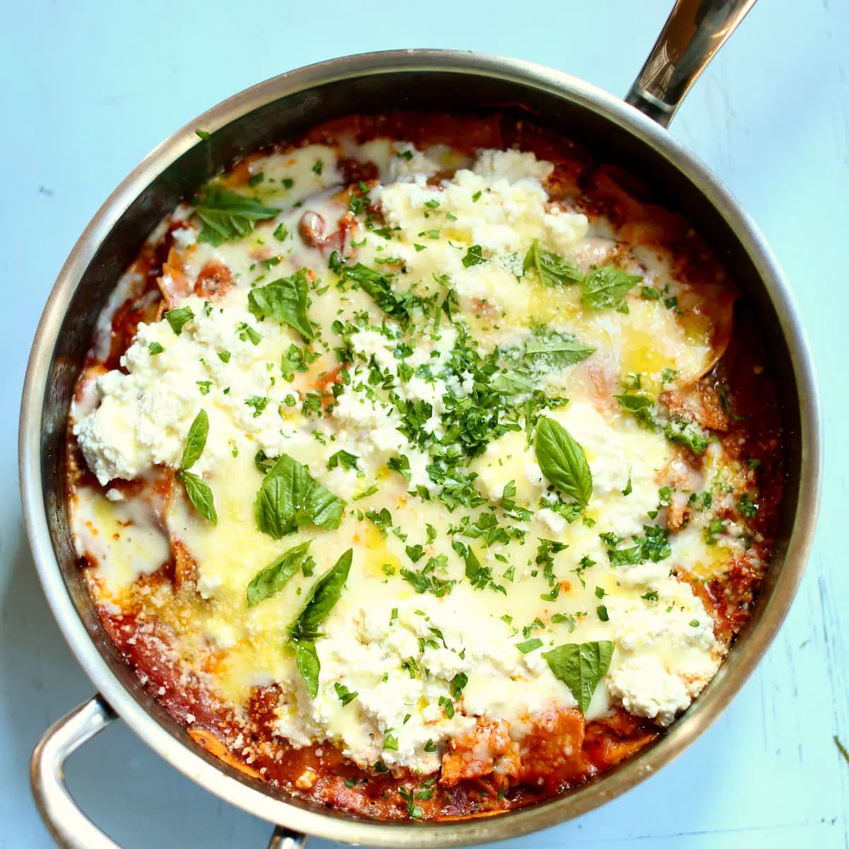 a skillet of pasta with cheese and ground turkey.