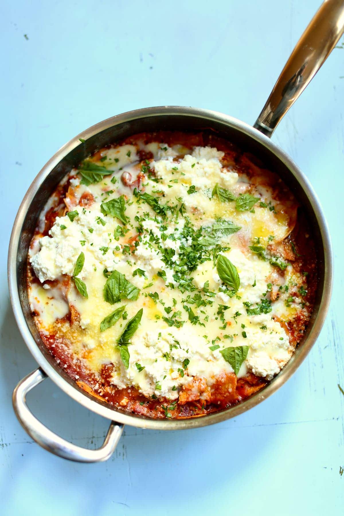 a skillet of pasta with red sauce and cheese.