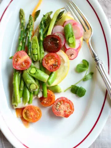 a white plate with chicken and vegetables on it.
