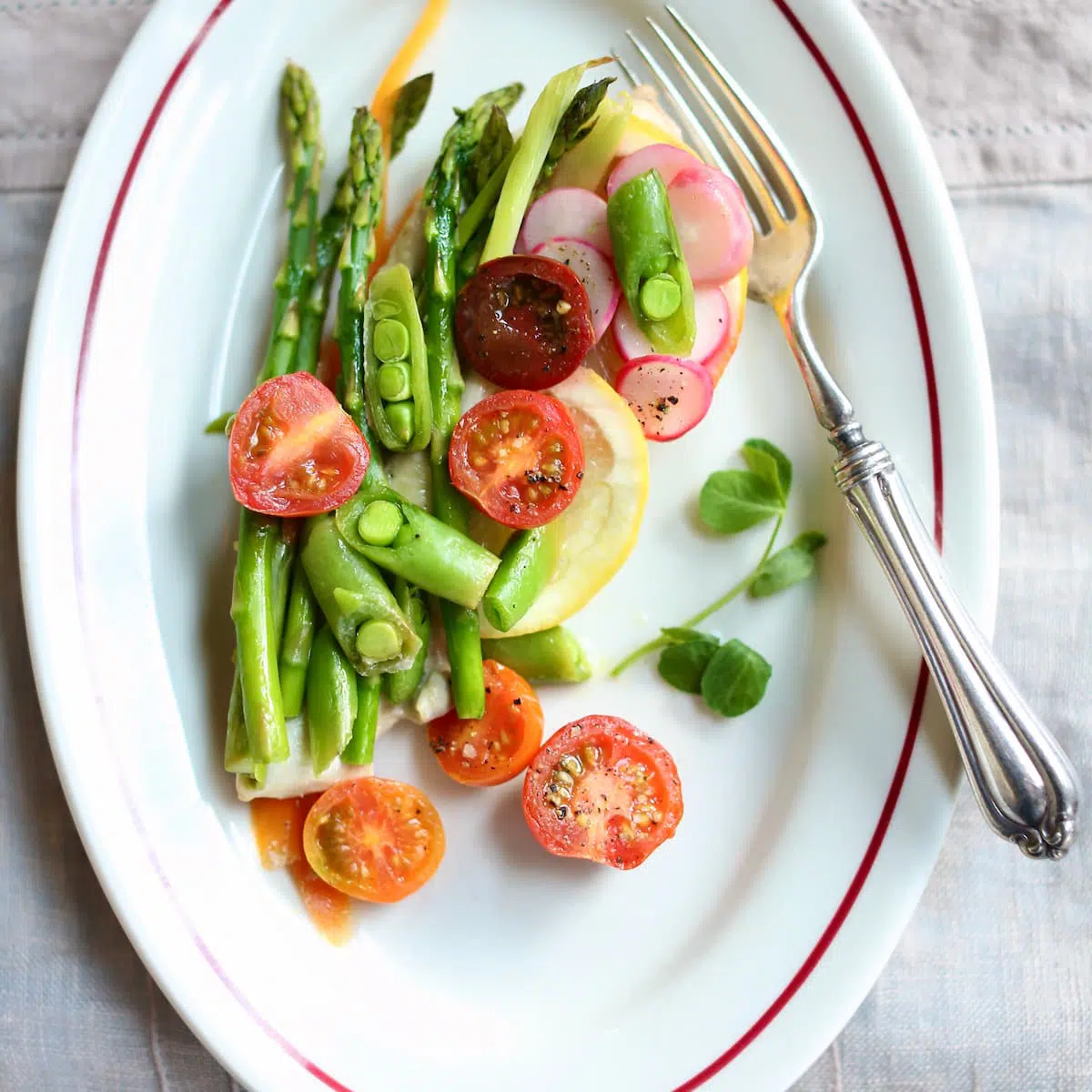 a white plate with chicken and vegetables on it.