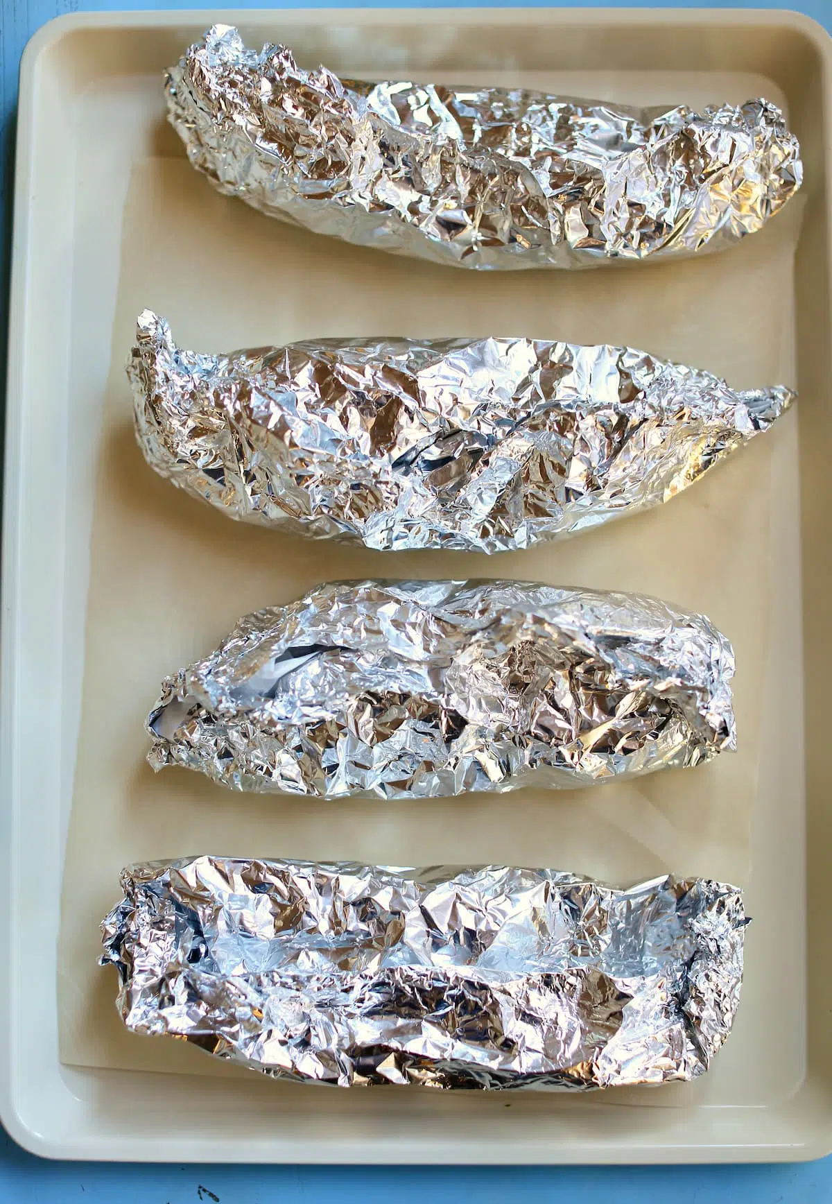 a sheet pan with tin foil wrapped chicken.