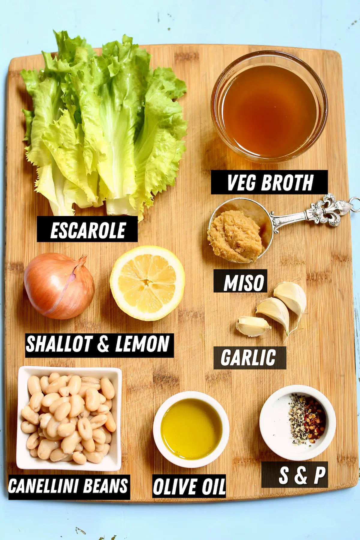 A cutting board with ingredients for soup.
